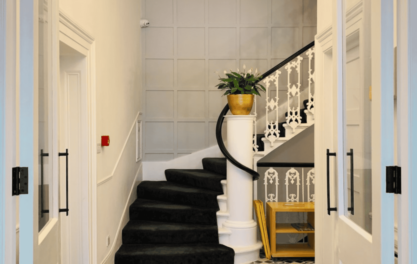Staircase with black carpet and elegant white railing inside Nikita portfolio.