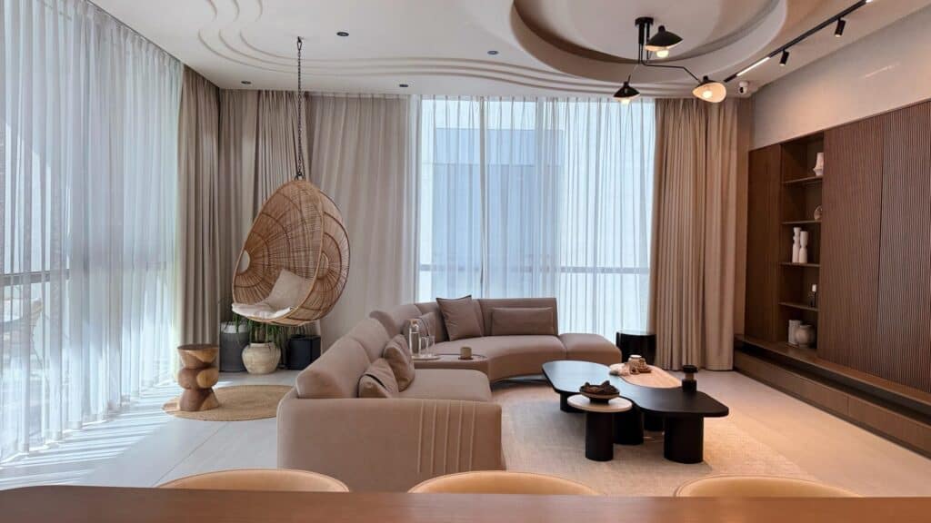Contemporary living room with beige sofa, large windows, and stylish decor.
